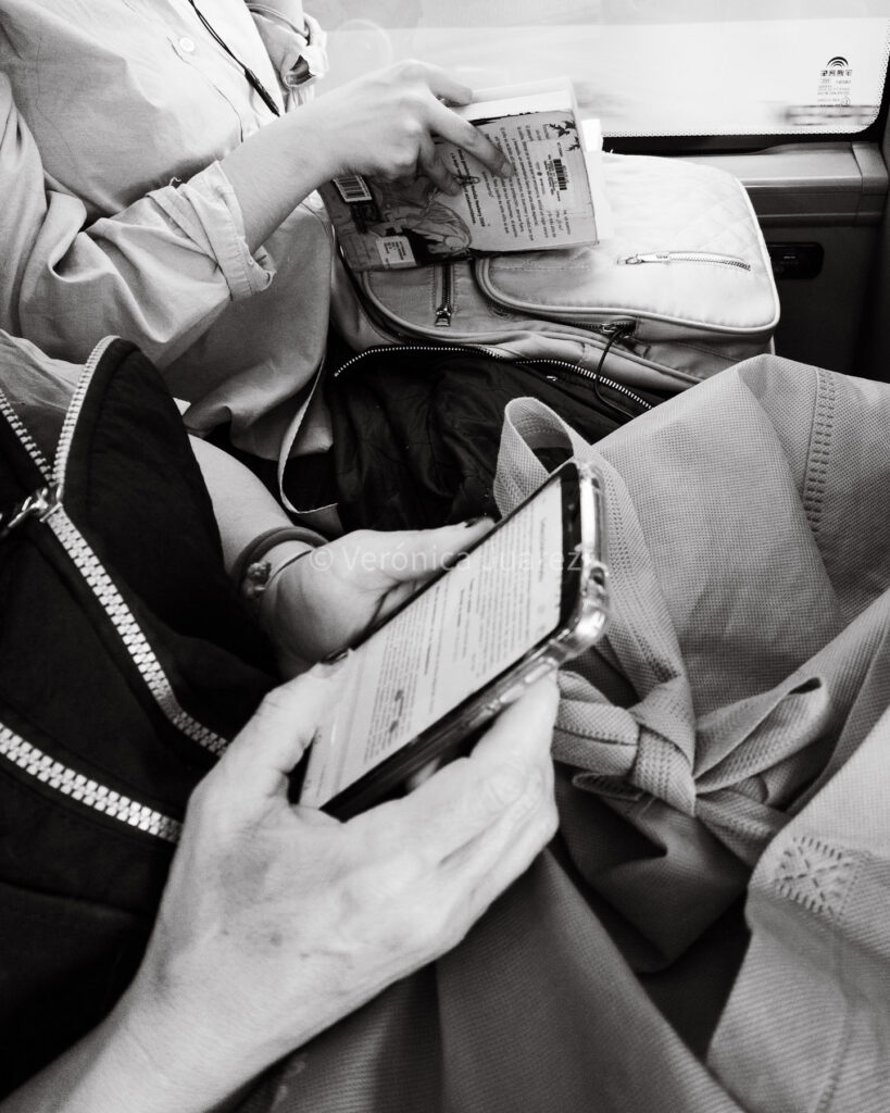 Dos personas leyendo en distintos formatos: una frente al teléfono móvil, otra en papel